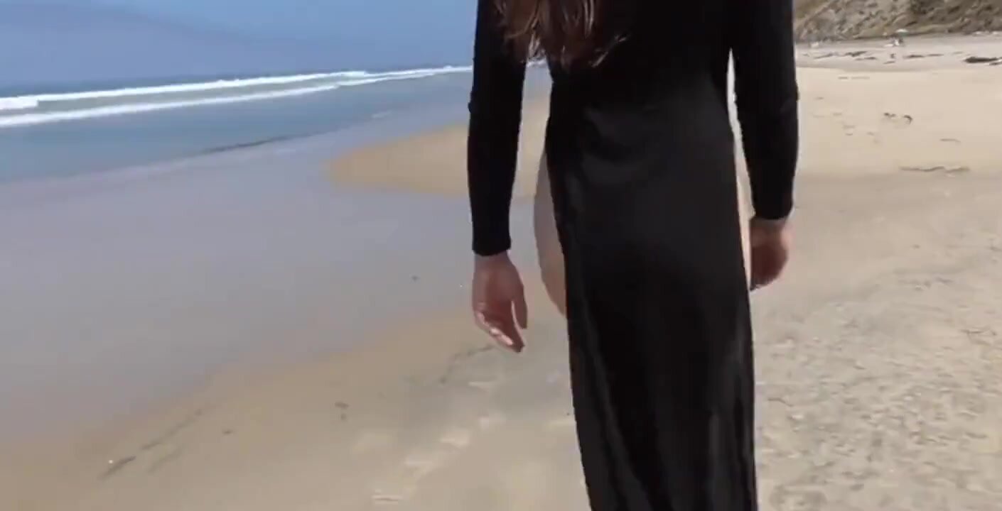 La giovane donna sta camminando completamente nuda sulla spiaggia pubblica
